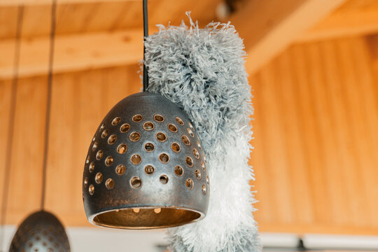 Cleaning dust with a pipidaster.lamp Cleaning . Pipidastr wipes dust from metal lamps.Fluffy duster and pendant lights