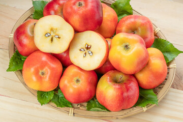 Sweet red star apple in basket on wooden table background,