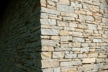 texture of a stone wall with rugged and wrinkled surface, characterized by a variety of earthy...