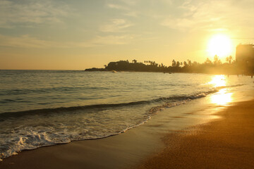 Beach with golden sand and blue ocean water on most popular Unawatuna