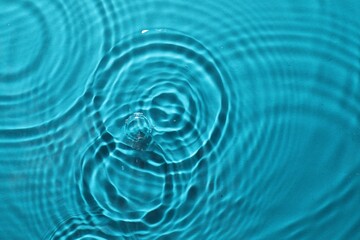 Naklejka na ściany i meble Rippled surface of clear water on light blue background, top view