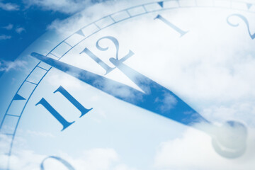 Time concept. Double exposure of blue sky with fluffy clouds and clock