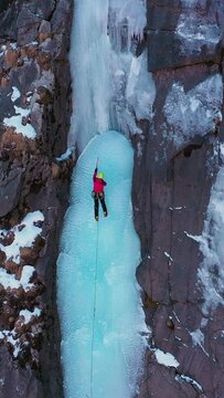Ice Climbing on Frozen Waterfall, Aerial View. Barskoon Valley, Kyrgyzstan. Drone is Orbiting. Vertical Video