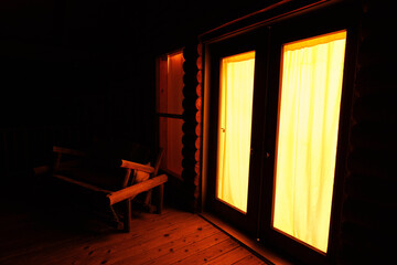 windows illuminated at night on the porch