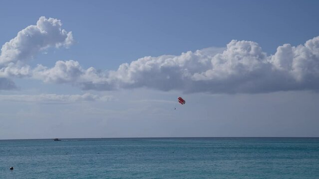 Parasailing with boat above blue ocean 4K