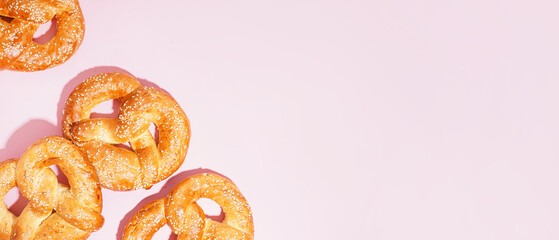 Tasty pretzels on pink background with space for text, top view