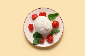 Plate with tasty Burrata cheese on yellow background