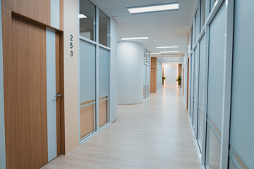Empty modern office bright corridor with glass wall. Long white modern office hallway. No...