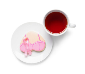 Heart shaped cookie with bra, pink ribbon and cup of tea on white background. Breast cancer awareness concept