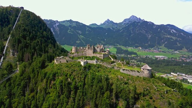 Panoramic aerial view of castle Ehrenberg at foothills of alps, Highline 179 pedestrian suspension bridge, and mountains in the background, Reutte, Austria