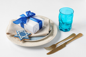 Festive table setting with Hanukkah decorations on white background