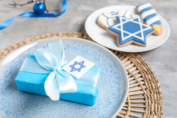 Festive table setting with Hanukkah decorations on grey grunge background, closeup