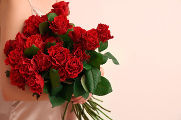 Young woman with bouquet of beautiful red roses on white background. Valentine's day celebration