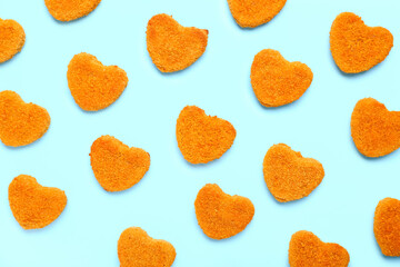 Tasty nuggets in shape of heart on turquoise background. Valentine's Day celebration