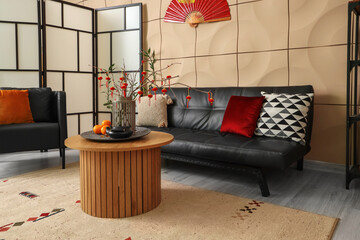 Interior of modern living room with black sofa, armchair and traditional Chinese decorations....