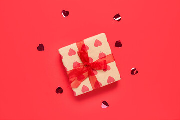 Gift box and confetti on red background. Valentine's Day celebration