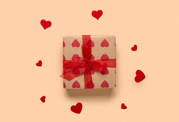 Gift box and hearts on beige background. Valentine's Day celebration