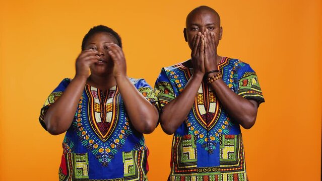 African american people doing three wise monkeys sign, covering their eyes, mouth and ears. Ethnic married couple advertising symbol to dont hear, speak or see bad evil things.