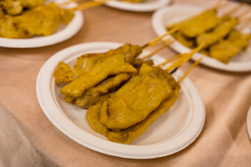 Moo satay or pork satay on white paper dish. Thai cuisine