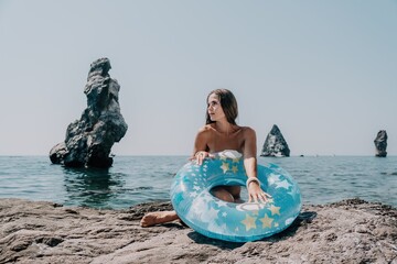 Woman summer sea. Happy woman swimming with inflatable donut on the beach in summer sunny day,...