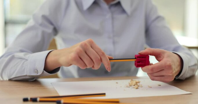 Secretary manager sits at table with pencil and sharpener