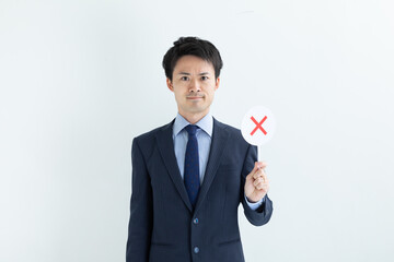 バツのプレートを持つ男性　NG