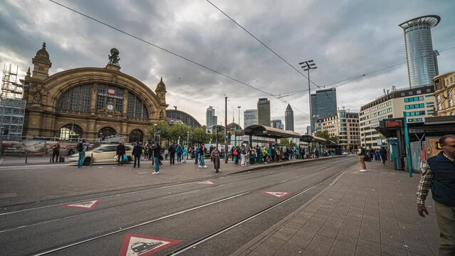 Time lapse of Crowd of People tourist walking and crossing road and tram station in front of Frankfurt (Main) Hauptbahnhof the city's grand main terminal station for regional & long-distance routes in