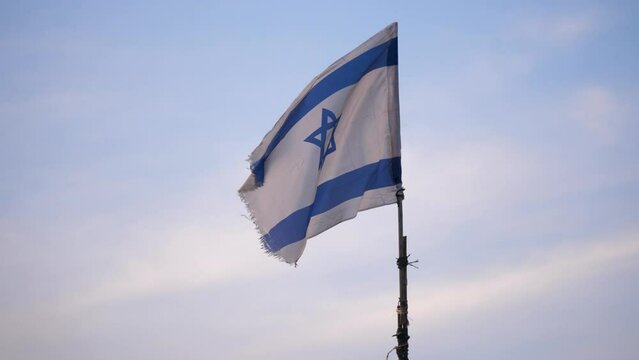 Israeli blue and white flag raised on a makeshift flagpole blows in the breeze