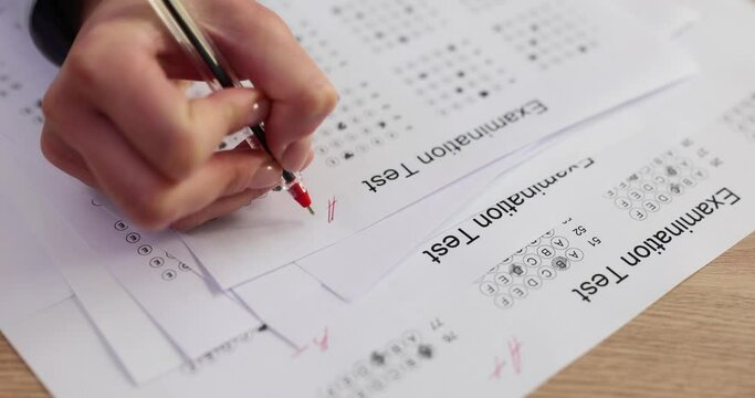 Teacher evaluates exam test and students answers and assigns grade