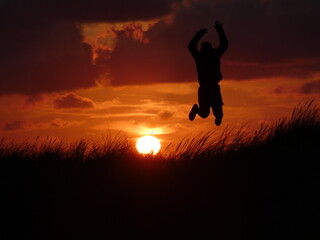 Silhouette eines glücklichen Jungen beim Sonnenuntergang