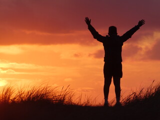 Fototapeta na wymiar Silhouette eines glücklichen Jungen beim Sonnenuntergang