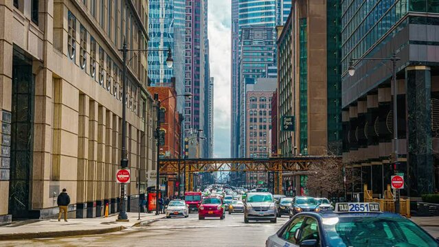 Time lapse of Crowd pedestrian and tourist walking and crossing intersection at Railroad bridge with traffic among modern buildings of Downtown Chicago, Illinois, United States