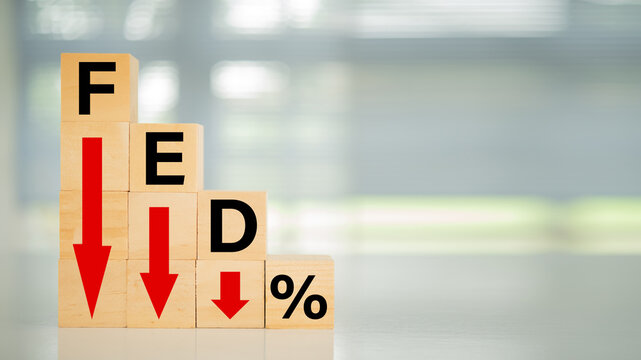 Federal Reserve bank interest rate reduction concept. Wooden blocks with fed and arrow go down.