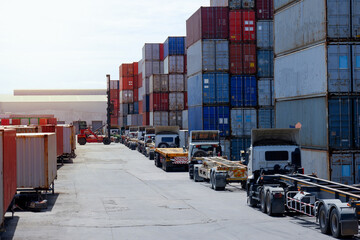 container truck and container forklifts Located behind a pile of containers.