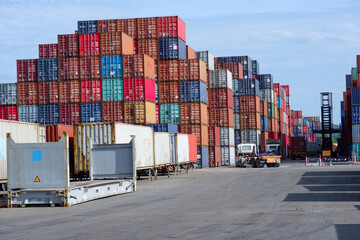 Containers piled up at the port - obrazy, fototapety, plakaty