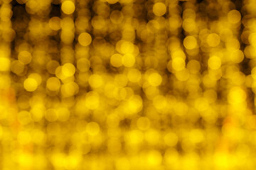 Blured festive garlands with glowing light bulbs against the background of the night sky.