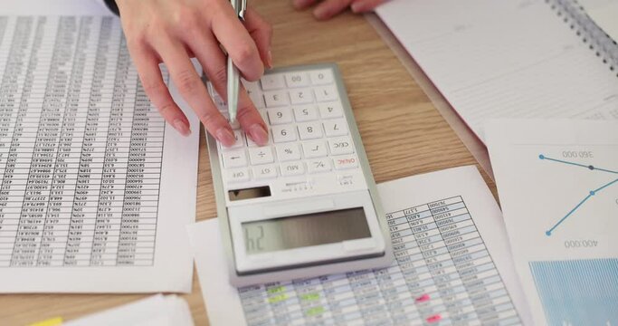 Businesswoman uses a calculator to calculate financial value of business
