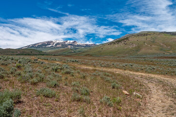 A dirt road curves toward the mountains near Elba, Idaho, USA