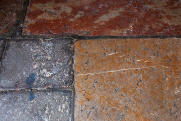Stone slabs in a church porch. Antique paving in several colors.