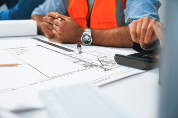 Diverse group of civil engineer and client working together on architectural project, building...