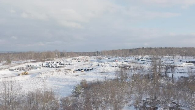 Snow Covered Outdoor Industrial Materials Supply Yard in the Winter, Aerial Flyover