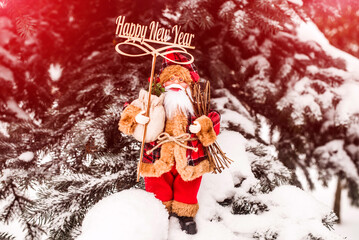 Santa Claus stands on the background of a snow-covered spruce
