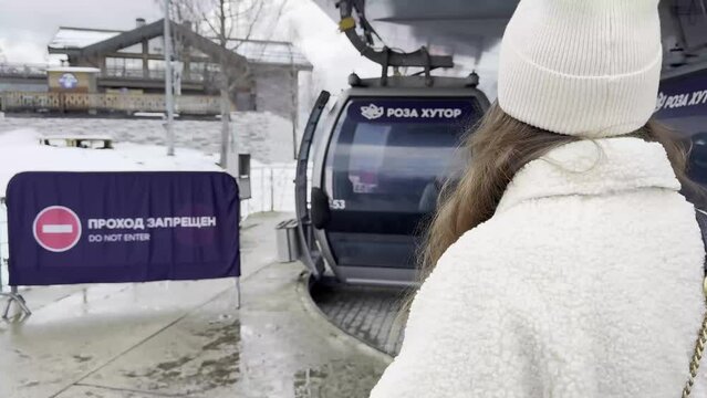 Russia, Sochi, December 2, 2023: A girl tries to use a ticket for a cable lift or elevator at the ROZA Khutor ski resort, passes through the turnstile