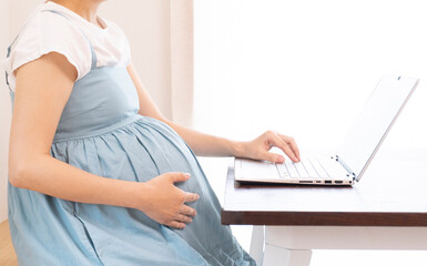 Asian pregnant woman joins online business meeting and talks to customers on video call.