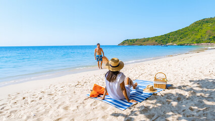 Koh Larn Island near Pattaya Thailand, the tropical beach of Koh Larn Thailand, a white beach with clear water ocean. Tropical Island. a couple of men relaxing on the beach with a sup board