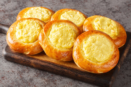 Shangi baked pies with potatoes Russian pastry closeup on the wooden board on the table. Horizontal