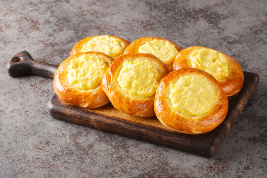 Shanga pies, a dish of Russian, Mari, Udmurt and Komi cuisine, filled with mashed potatoes, close-up on a wooden board on the table. Horizontal