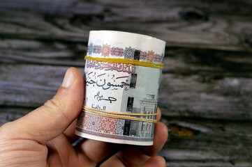 Egypt money roll pounds isolated on wood background, 50 LE fifty Egyptian pounds cash money bills...