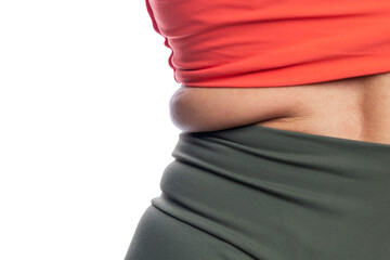Side fold of fat in a woman in sportswear. Health, sports and excess weight. Isolated on a white background. Close-up.