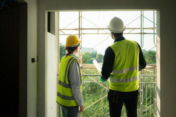 Engineer and architect working on the construction site, double-checking plans and process.